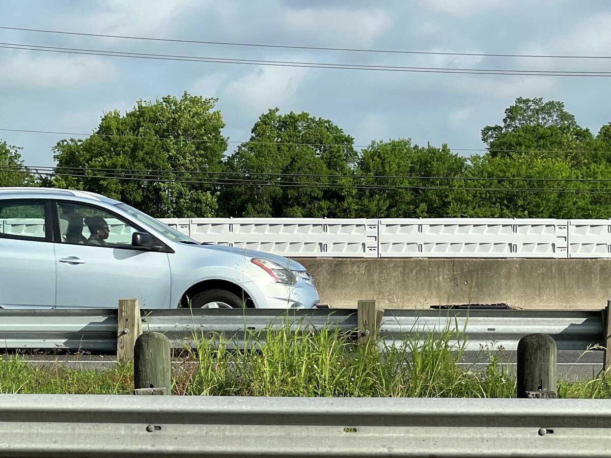 A driver travels north on Interstate 69 near Bissonnet Street on Tuesday, May 10, 2022, near new plastic barriers that line the center median. Installed in April 2022 by the Texas Department of Transportation, the barrier is in an effort to dissuade pedestrians from crossing the highway.