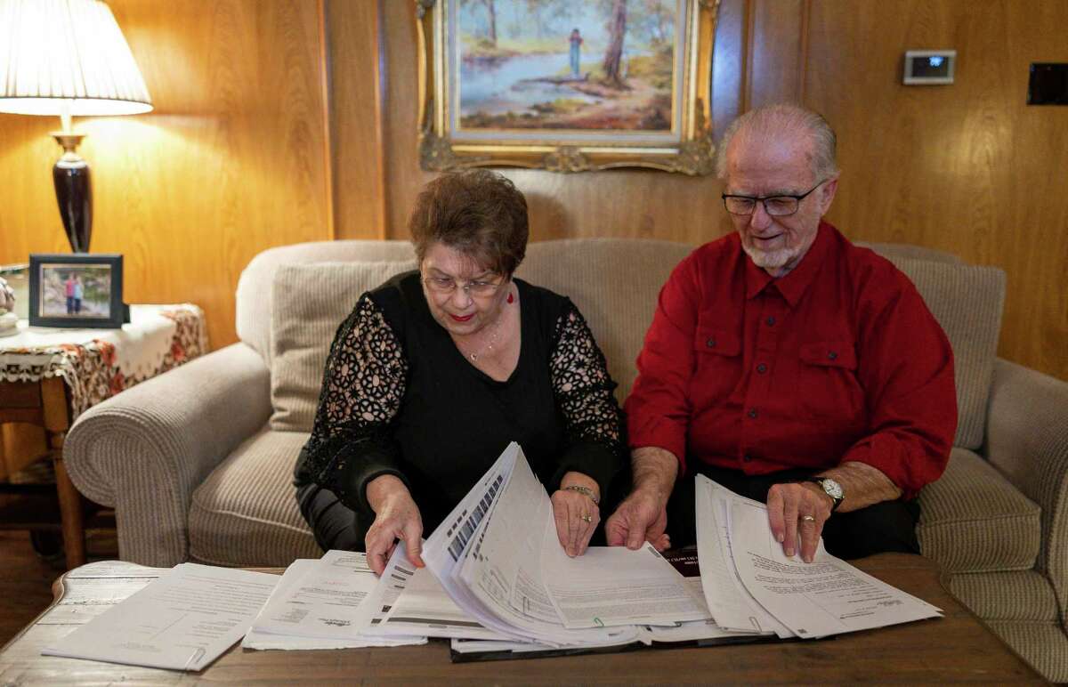 Lewis "Deakon" and Mary Keener, who are suing Bank of America for a violation of the Fair Debt Collection Practices Act, sort through a portion of the documents they have been saving to document their case in their home, Tuesday, Feb. 1, 2022, in Dallas. The couple say their credit card was fraudulently used to secure a $17,000 line of credit, which was used to purchase cruise tickets and airfare. After the Keeners tried to correct the problem by calling the bank and issuing letters, even filing a police report, the bank ignored this and hired a debt collector to go after the money. Then the couple was sued in county court for the debt.