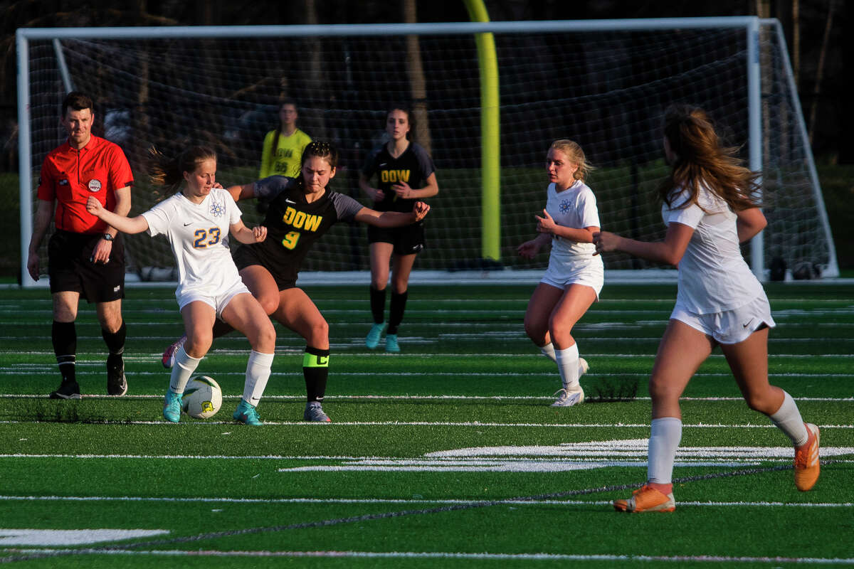 Dow High's Alaina Schalk (right) fights for possession during Monday's game against Midland High, May 9, 2022.