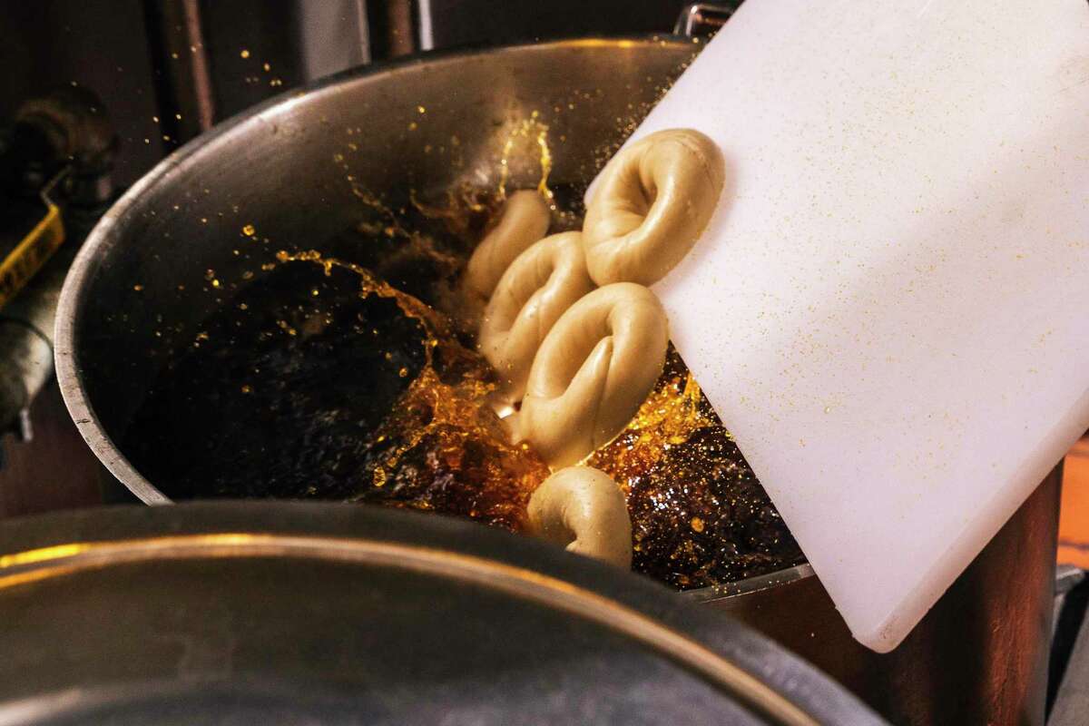 在奥克兰的一家小卖部厨房里，罂粟面包圈面团滑入一锅沸水中。