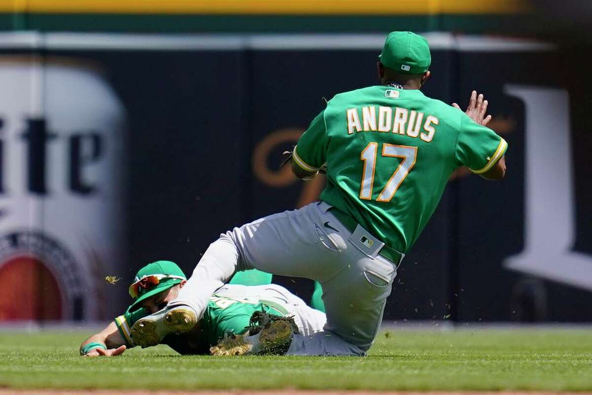 Oakland Athletics left fielder Chad Pinder and shortstop Elvis Andrus collide while trying to field a Detroit Tigers' Harold Castro pop fly that landed for a single in the fifth inning Tuesday in Detroit.
