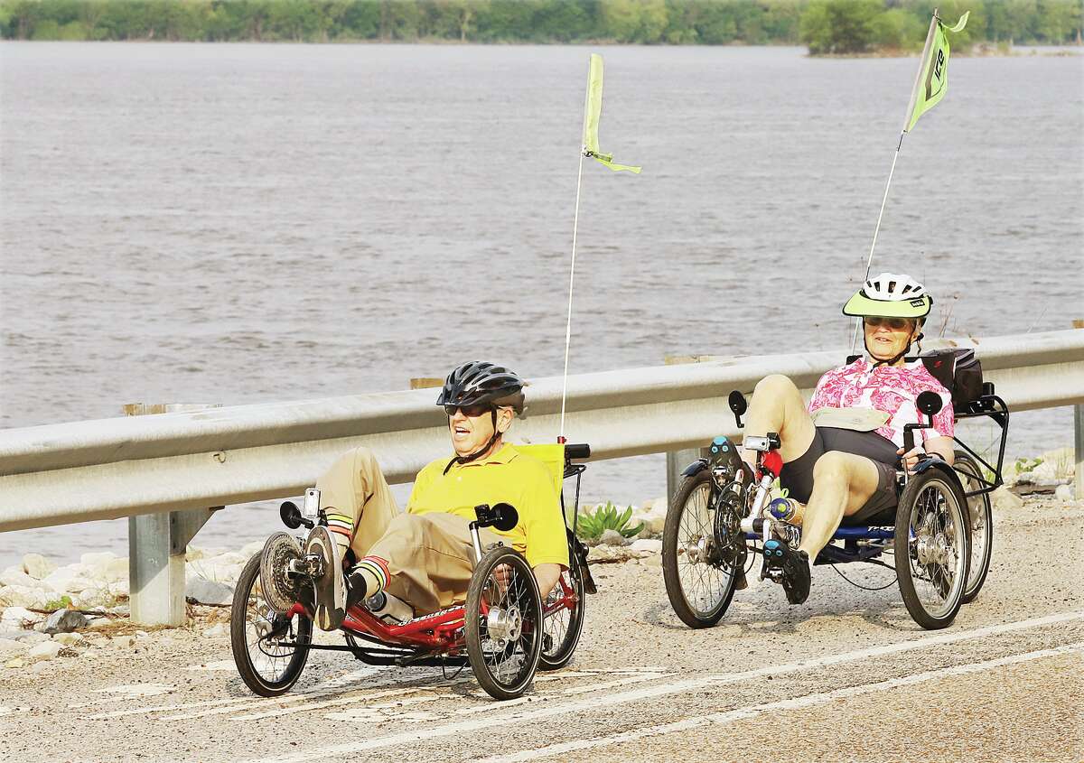 John Badman|The Telegraph A couple rides the bike trail along the Great River Road in Jersey County Tuesday taking advanatage of a cool morning before the sun broke through the haze and heated up the day. The couple were riding tadpole trikes, a form of recumbent bike which has three wheels and reclined seating. The trikes are popular with seniors and are better for back pain relief than a traditional bicycle.