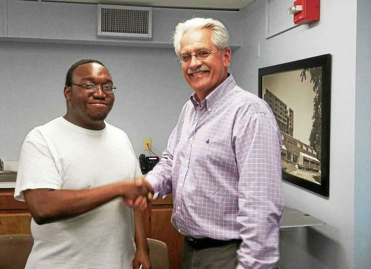 Middletown Housing Authority Executive Director William Vasillou, right, congratulates now Vinal Technical High School student Clayton Smith, left, on his scholarship.