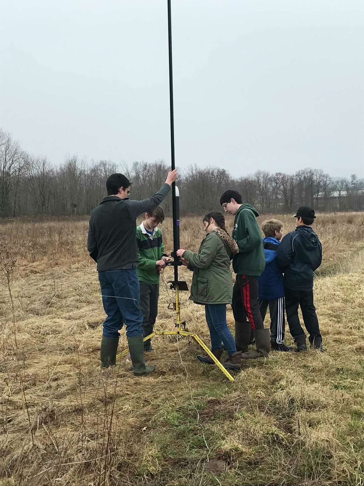 The rocketry team putting the rocket on the launch pad and getting it ready for launch at one of the practice flights in Durham. From left, Peter Sebestyen, Damien Seidman, Amelia Lekovic, John Paul Sebestyen, Brian Daniels, Adam Wilder. Not pictured; Adriel Lekovic.