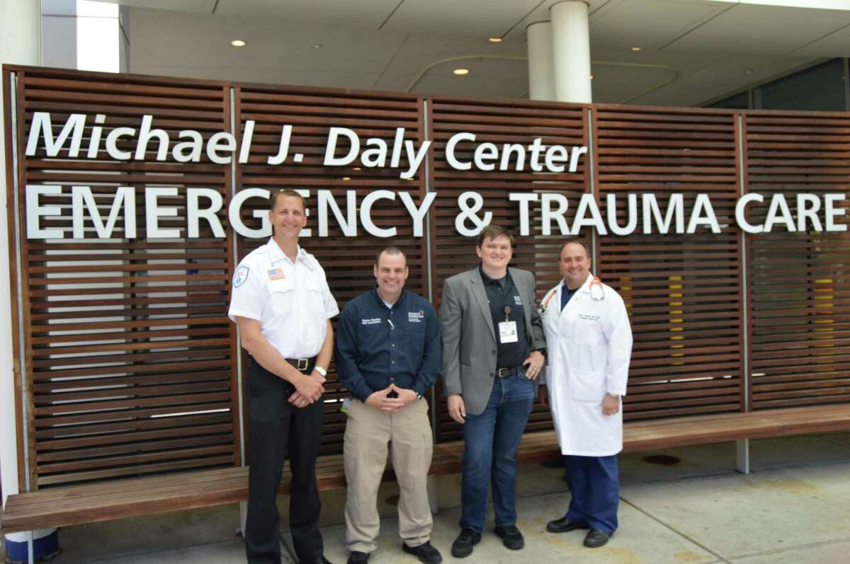 Healthcare professionals Kevin Ferrarotti, Terence Sheehan, James Powell and Steven Valassis pose in front of the emergency room entrance at St. Vincent's Medical Center.