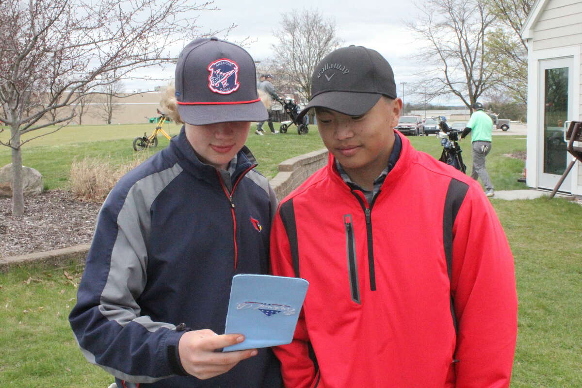 Big Rapids' Preston Younge (left) compares scores with teammmate Kyle Schroeder after a recent match.