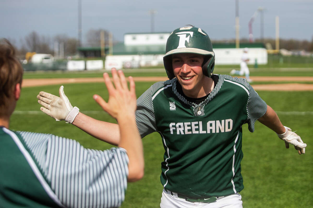 Freeland's Jacob Kowalski high-fives a teammate during a game against Essexville Tuesday, May 10, 2022 at Freeland High School.