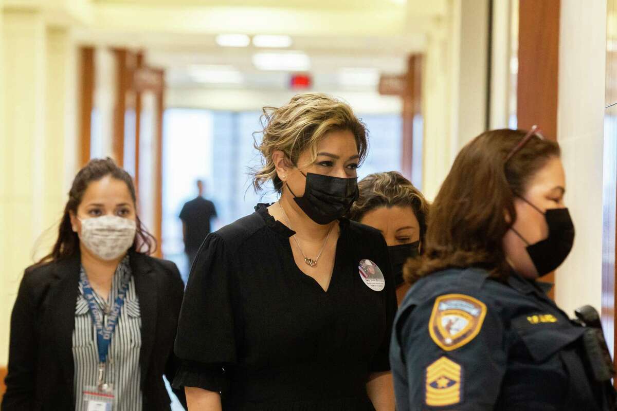 Harris County Sheriff's Office Deputy Darren Almendarez's wife, Flor Zarzoza, center, enters the Texas 177th District Court at the Harris County Criminal Courthouse, Tuesday, May 10, 2022, in Houston. Zarzoza attended a hearing to determine whether the three people accused in the death of her husband should continue being held without bond.