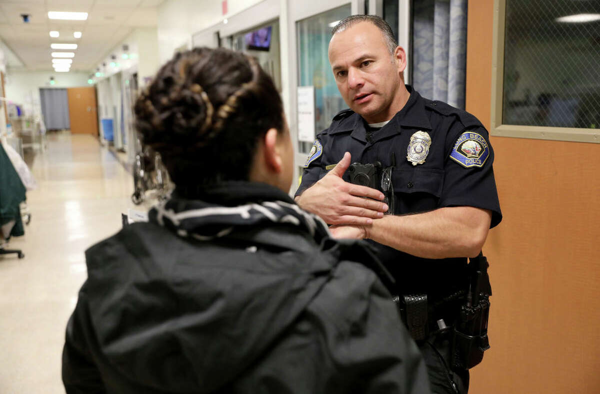 Silvia Gomez, a children's social worker with the emergency response command post in Los Angeles County, speaks to Long Beach Police officer George Nogueira. (Photo by Guy Wathen/San Francisco Chronicle via Getty Images)