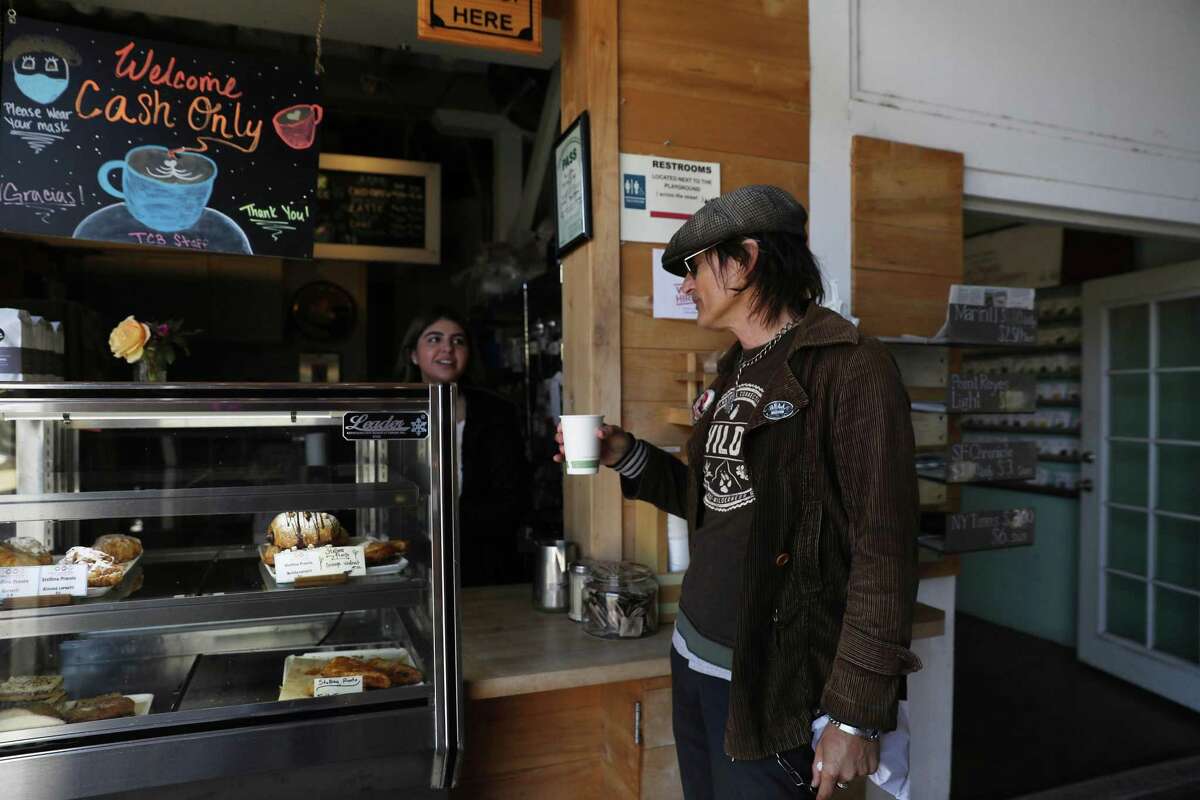 Johnny Dimorente of Point Reyes Station talks with manager Esme Gutierrez manager, as he picks up his beverage in a compostable cup from Toby’s Coffee Bar.