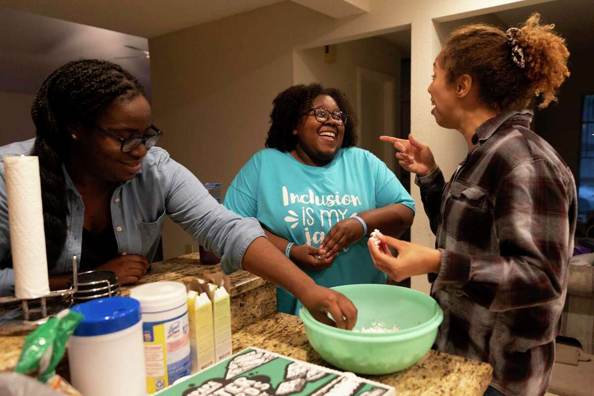 Jhonelle Bean, center, laughs with her friends, Eryn Young and Lauren Miller before starting an impromptu game night. Bean, 27, left a San Antonio home where she experienced abuse and moved into Presbyterian Children’s Homes and Services’ transitional living facility until she became financially self-sufficient. Today she lives in her own apartment.