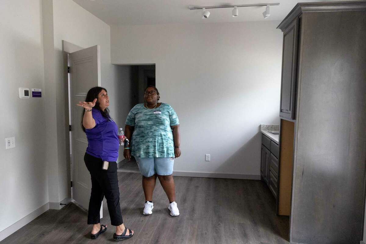 Jhonelle Bean, 27, is shown freshly constructed efficiency apartments in the newly built transitional living center at Presbyterian Children’s Homes and Services’ San Antonio campus. Mari Molina, left, is senior coordinator for the transitional living program. Bean lived at the nonprofit’s previous transitional housing building from 2019 to 2021 after she left a home where she had previously suffered abuse.