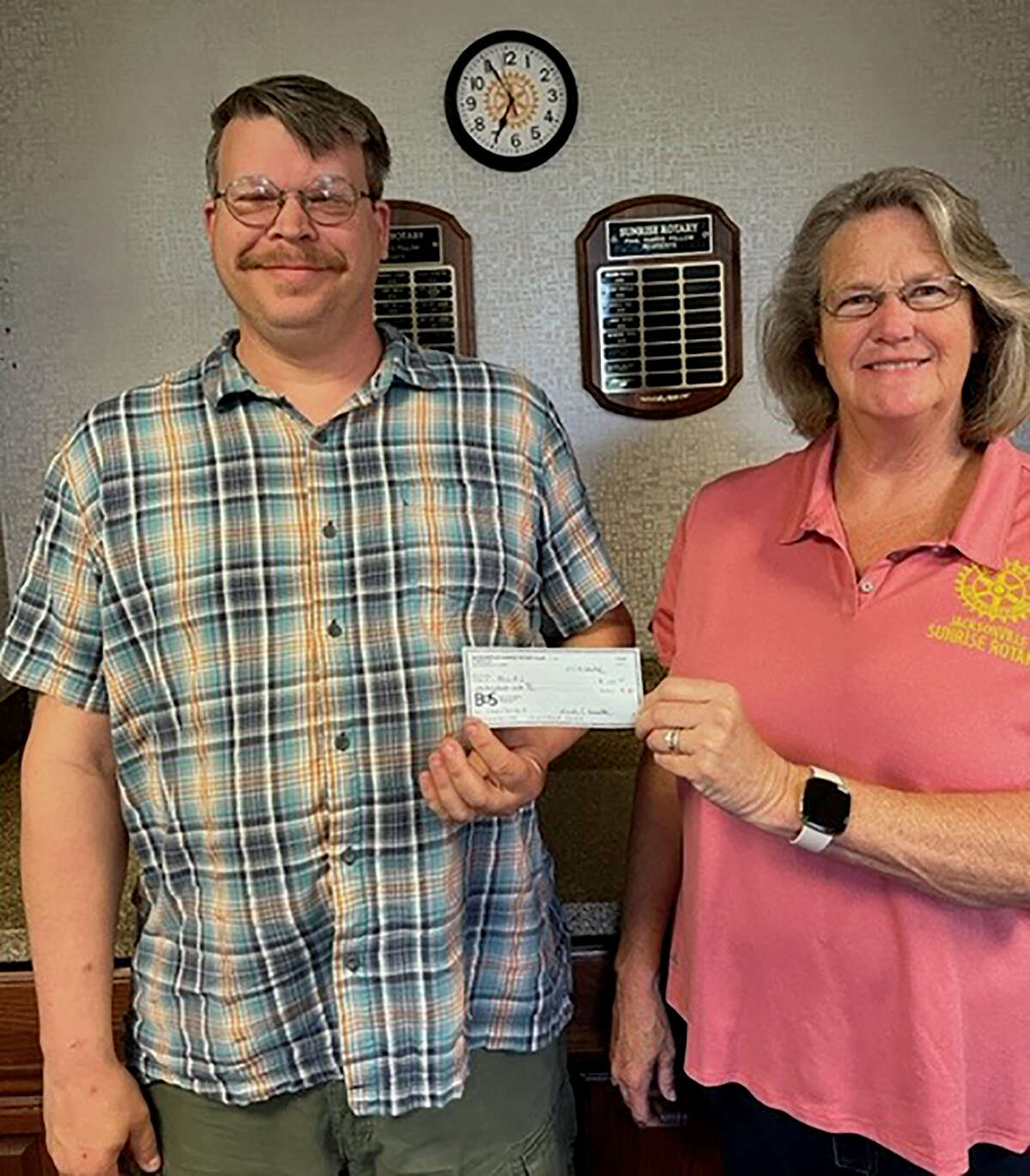 Jane Becker, president of Jacksonville Sunrise Rotary Club, presents a $100 check to Chad Boehlke, coordinator for the 2022 Prairieland Chautauqua. The funds donated by the club are to benefit the Chautauqua, which will be Sept. 2-3 — Labor Day weekend — at the Nichols Park pavilion. Admission is free and open to the public.