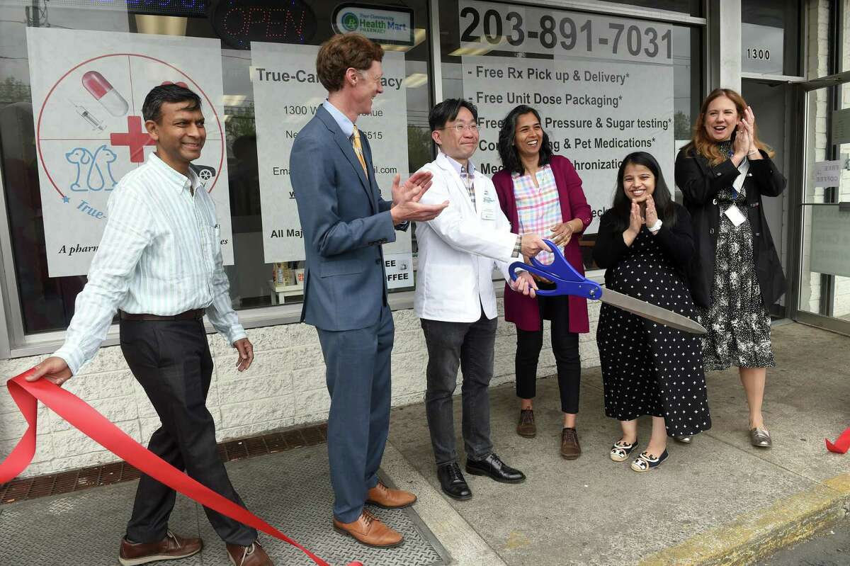 Viktor Fok, center, co-owner and pharmacy manager of True-Care Pharmacy, is applauded at a ribbon-cutting ceremony for the business at 1300 Whalley Ave. in New Haven Wednesday.