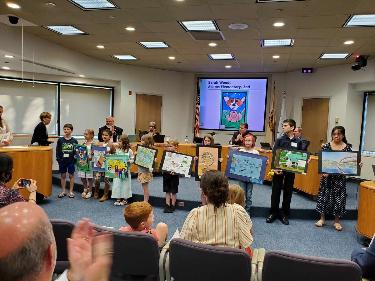 Students who participated in the Make Midland Beautiful Art Celebration hold up their artwork at a Midland City Council meeting on May 9, 2022 in Midland City Hall.