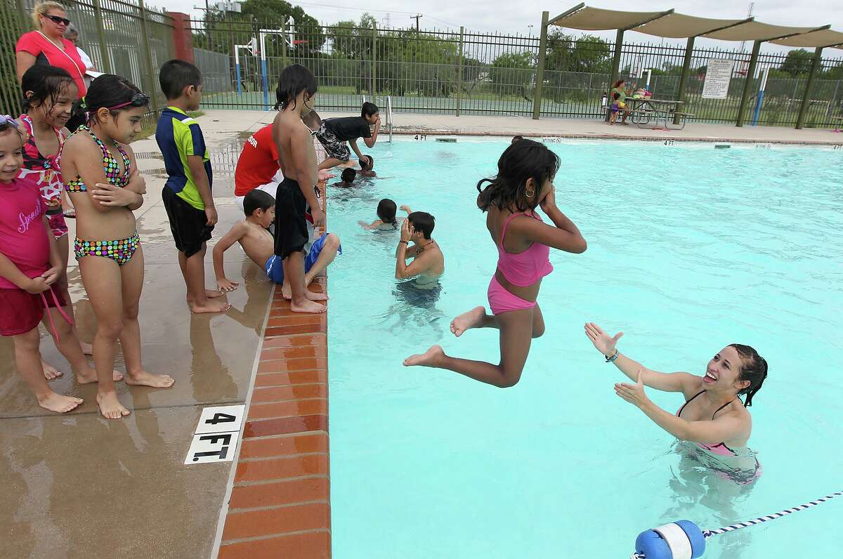 Guadalupe Duran, 6, jumps into the arms of lifeguard Taylor Spain at Lady Bird Johnson Park’s swimming pool in this 2012 photo. The city is opening eight of its pools, including the Lady Bird Johnson Pool, this weekend.