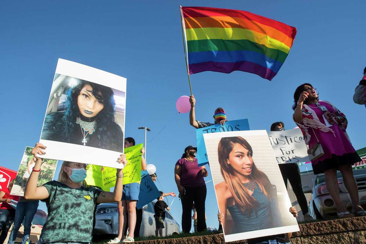 Louvier Santos, left, holds up a photo of her sister, Iris Santos, a transgender woman shot to death outside a Chick-Fil-A restaurant two weeks ago, as she joins friends and family to hold a vigil for her Wednesday, May 5, 2021 in Houston. Santos was fatally shot as she sat at a picnic table outside the fast food restaurant around 9:32 p.m. April 23 in the 8600 block of Westheimer Road. A manager found Santos on the north side of the restaurant. Police are still searching for a suspect in the case.