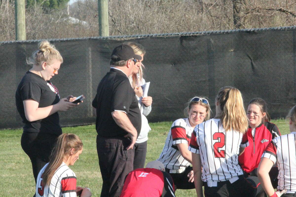 Reed City softball coach Roger Steig (middle) talks to his team after a recent contest.