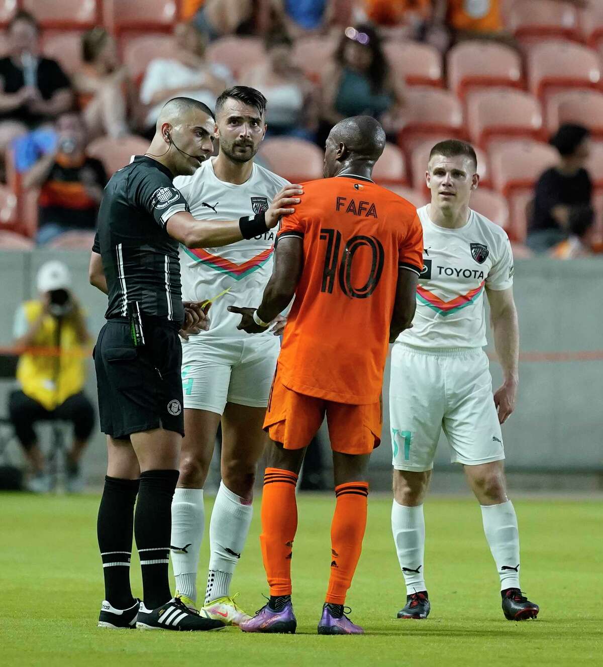 The referee speaks with Houston Dynamo midfielder Fafà Picault (10) and San Antonio FC defender Fabien Garcia (4) during the first half of the U.S. Open Cup soccer match at PNC Stadium on Wednesday, May 11, 2022 in Houston.