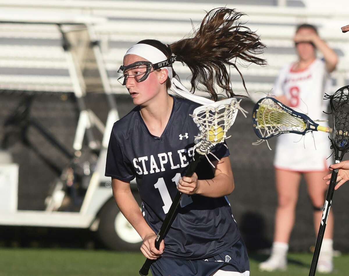 Staples' Mia Didio (11) works with the ball on offense during a girls lacrosse game in New Canaan on Tuesday, May 10, 2022.