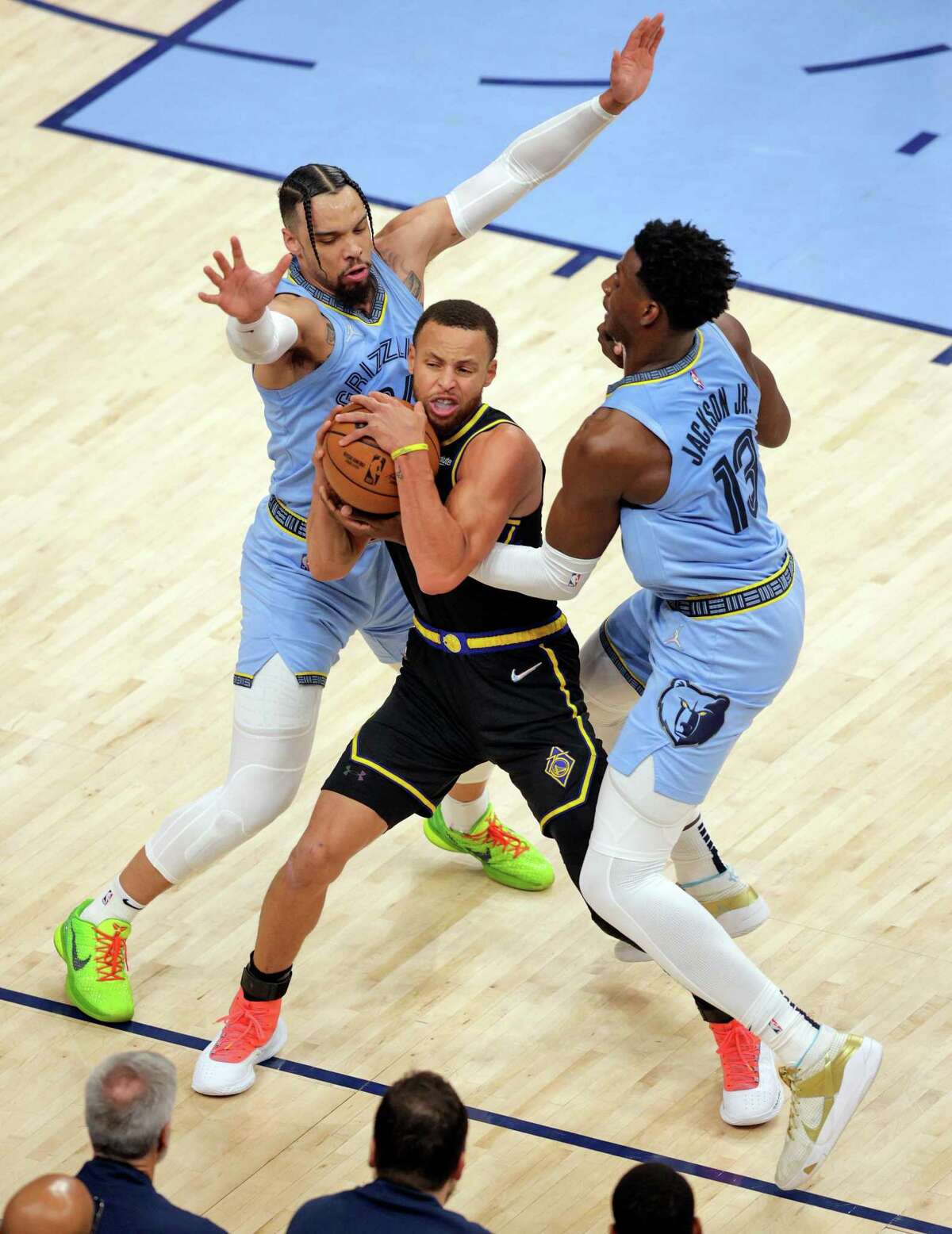 Dillon Brooks (24) and Jaren Jackson Jr. (13) try to wrestle the ball away from Stephen Curry (30) In the first quarter as the Golden State Warriors played the Memphis Grizzlies in Game 5 of the Western Conference Semifinals of the NBA Playoffs at Fedex Forum in Memphis, Tenn., on Wednesday, May 11, 2022.