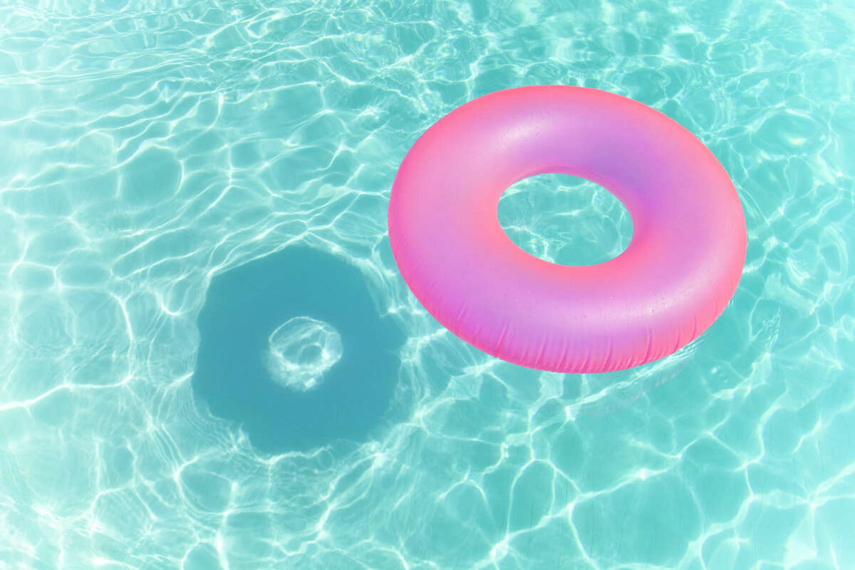 A float is pictured in a pool casting a shadow on the pool floor. 