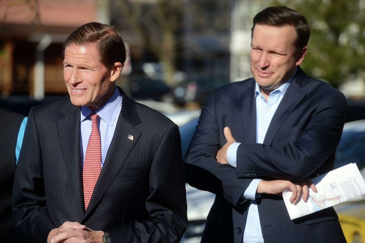 U.S. Senators Richard Blumenthal and Chris Murphy listen as Gov. Ned Lamont speaks during a news conference at the rail station in Ansonia, Conn. Nov. 8, 2021.