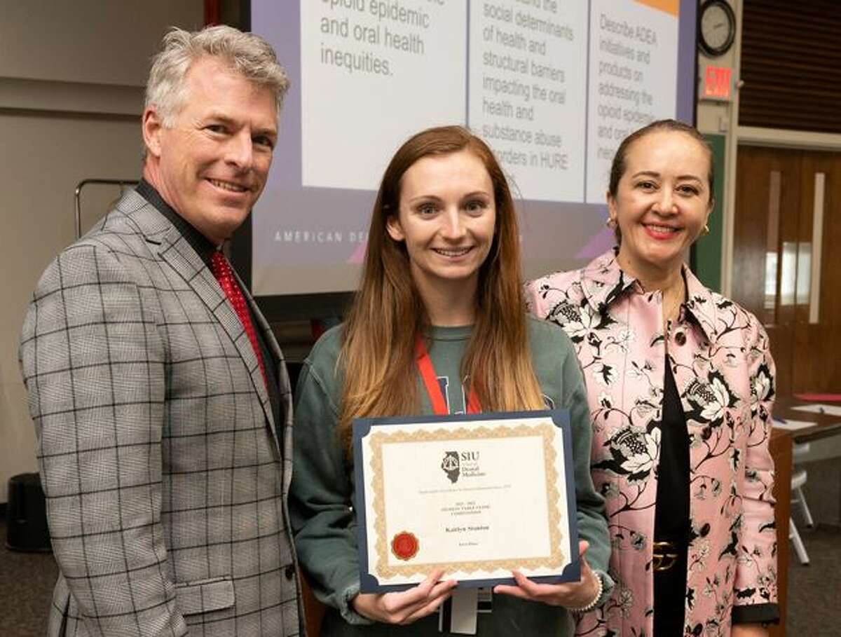 Second-year SIU SDM student Kaitlyn Stanton (center) took first place in the Research Day Student Table Clinic Competition. She stands with SIU SDM Interim Dean Duane Douglas, DMD, and SIU SDM Interim Director of Research and Chair of the Department of Applied Dental Medicine Nathalia Garcia, DDS, MS.