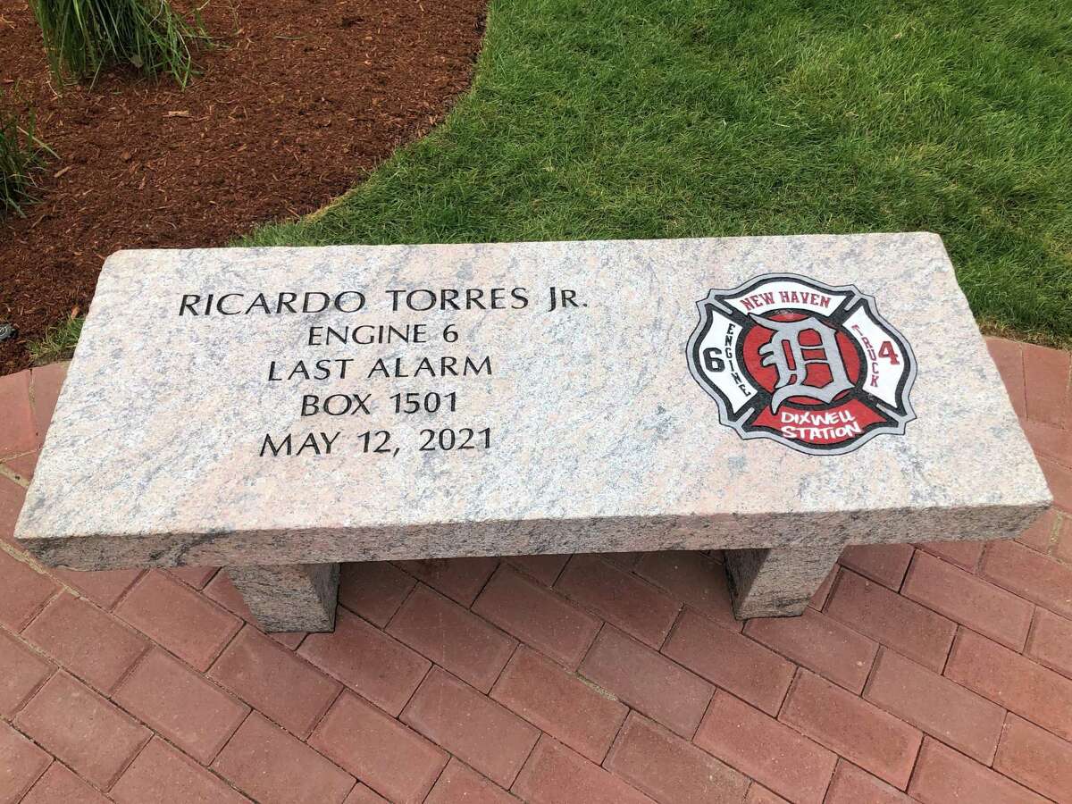 New Haven firefighters and family remembered Ricardo Torres Jr. Thursday, one year after he died fighting a fire on Valley Street. Here, a bench outside the Dixwell station, unveiled by his colleagues, bearing Torres’ name.