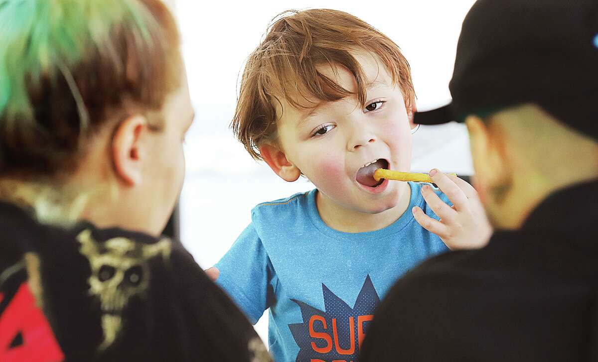 John Badman|The Telegraph Benjamin Allen, 5, of Alton enjoys some hot French fries on a hot day at the Flock food truck park, 210 Ridge St. in Alton. The new food truck park officially opened Thursday for lunch.