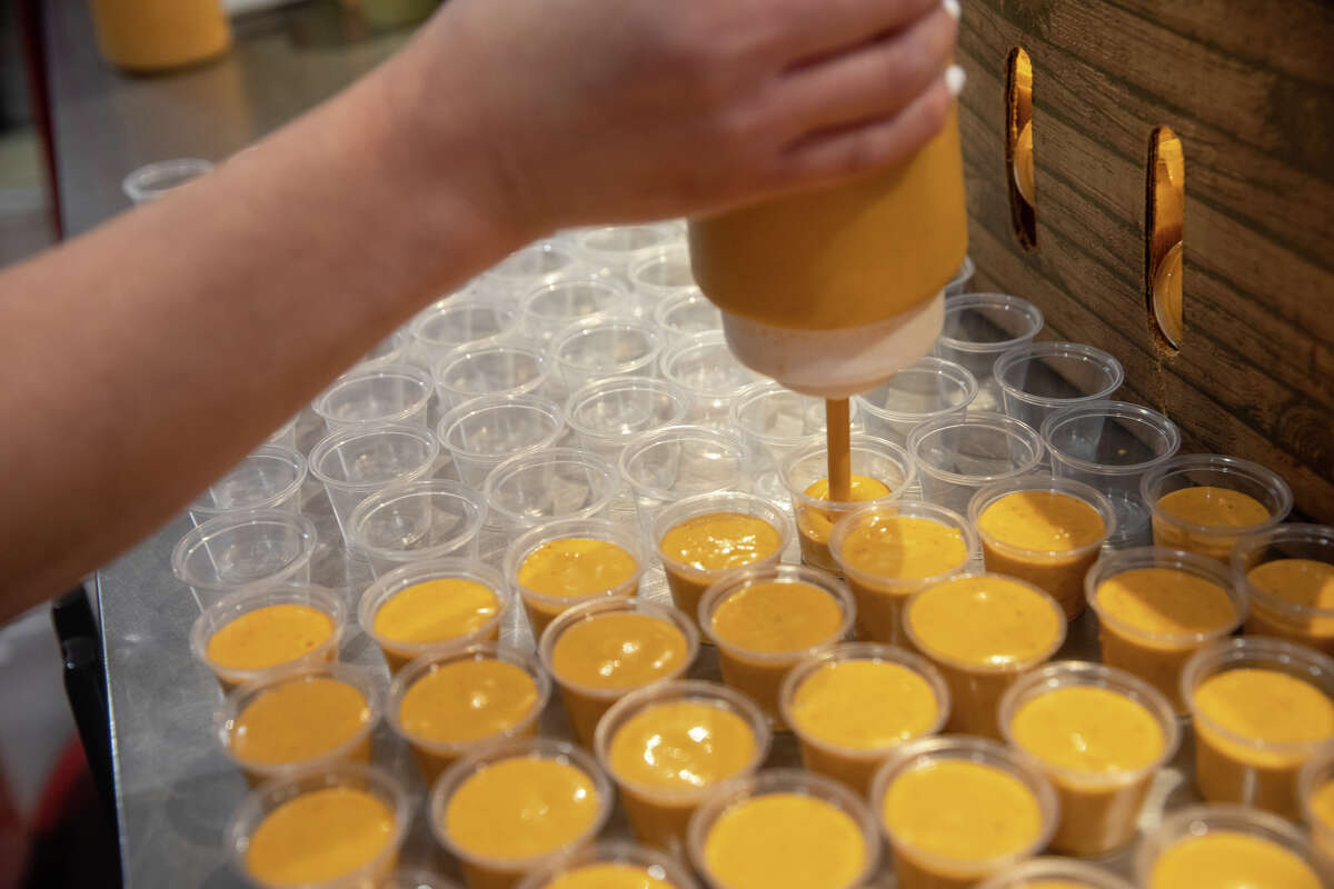 Pracownik napełnia pojemniki sosem pomarańczowym marki La Victoria Taqueria w San Jose w Kalifornii, 10 maja 2022 r.