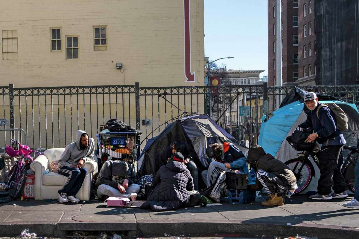 People gather at a homeless encampment at the corner of Turk and Hyde streets in San Francisco’s Tenderloin neighborhood in October.
