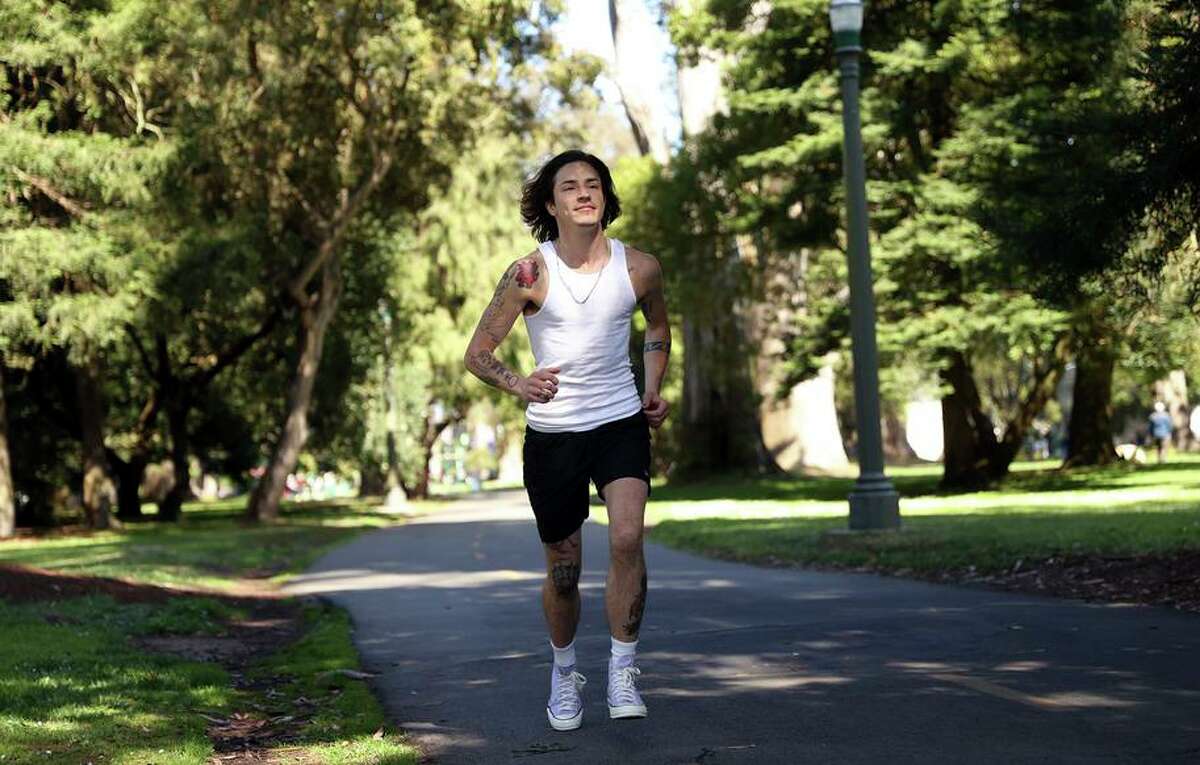 Cal Calamia runs along a path in San Francisco on Thursday, May 12, 2022. Calamia is non-binary and is considering not participating in the Bay to Breakers race because the organizers do not offer a separate award category for non-binary runners.