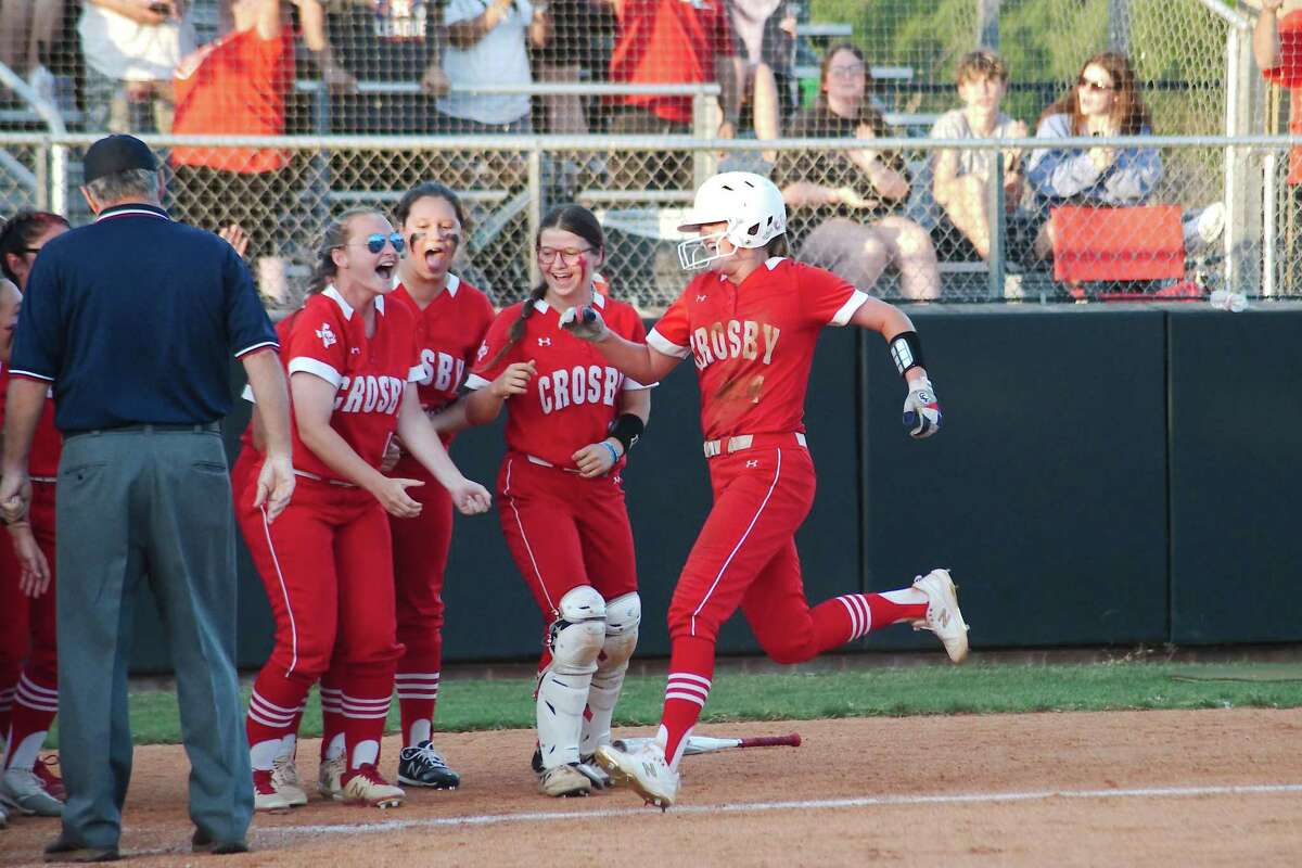 Crosby's Trista Brown (4) is swarmed by teammates after hitting a home run against Friendswood Thursday, May 12, 2022 at Friendswood High School.