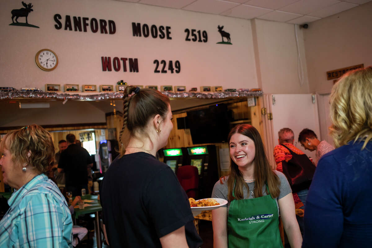 Kassidy Zmikly, right, chats with a friend during a fundraising event for her sister, Karleigh Zmikly, and Carter Bean, who are recovering from an April 3 off-road vehicle crash in Gladwin, Wednesday, May 11, 2022 at the Sanford Moose Lodge.