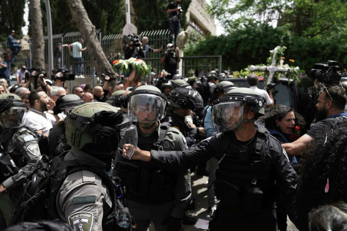 Israeli police in riot gear confront mourners and the journalists covering the transfer from the hospital of slain Al Jazeera veteran journalist Shireen Abu Akleh to her final resting place, in east Jerusalem, Friday, May 13, 2022. Abu Akleh, a Palestinian-American reporter who covered the Mideast conflict for more than 25 years, was shot dead Wednesday during an Israeli military raid in the West Bank town of Jenin.