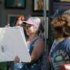 Gail Wescott looks through artwork she purchased during The Woodlands Waterway Arts Festival at Town Green Park, Saturday, April 9, 2022, in The Woodlands.