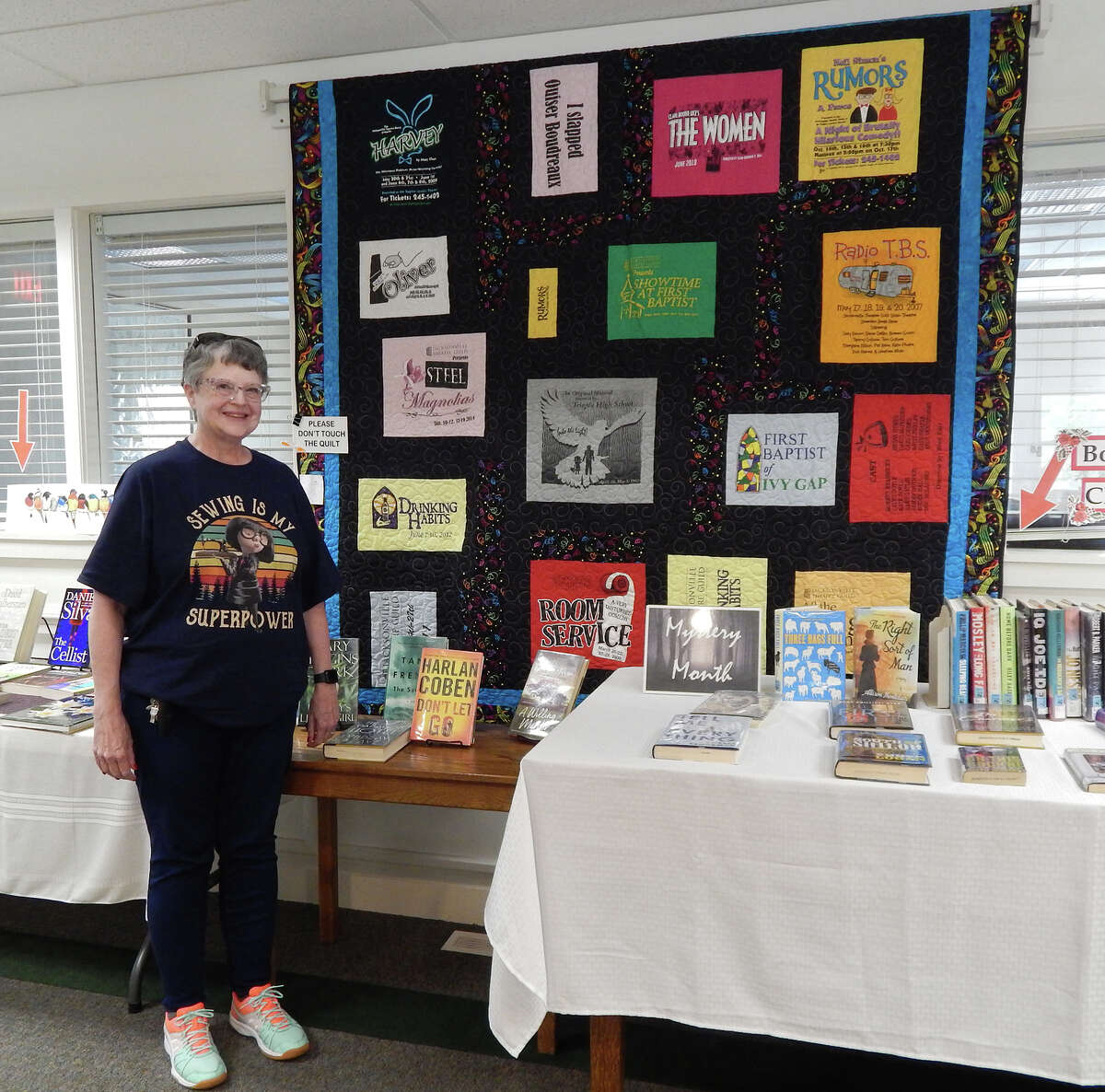 Tammy Guthrie of Jacksonville stands near her quilt honoring Jacksonville Theatre Guild where it is on display during May at Jacksonville Public Library.
