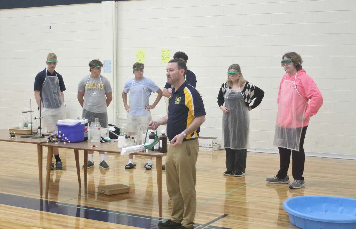 Manistee High School science teacher Ryan O'Donnell speaks to Kennedy Elementary students during a demonstration put on by Advanced Placement chemistry students.