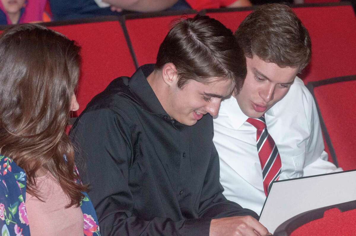 A group of Jacksonville High School seniors look over scholarships they received Thursday as part of the school's recognition of outstanding academic achievement and contributions toward excellence.