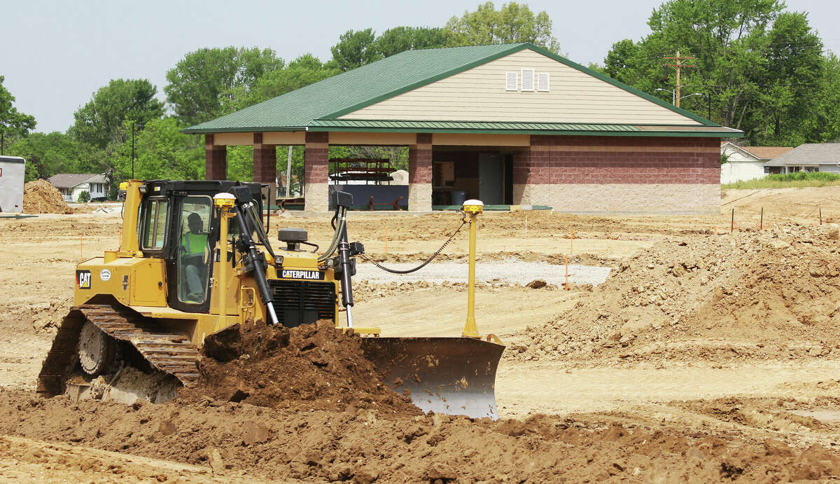 A worker moves earth Friday morning during construction of a new recreational complex at Glazebrook Park in Godfrey. The project includes a new concession and restroom building, pickleball courts, a new playground, fitness stations, a lacrosse field and a splash pad. 