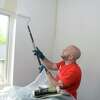Volunteer Jose Lopez of Guaranteed Rate Affinity paints in a bedroom at Amos House, in Danbury, Conn. May 12, 2022.
