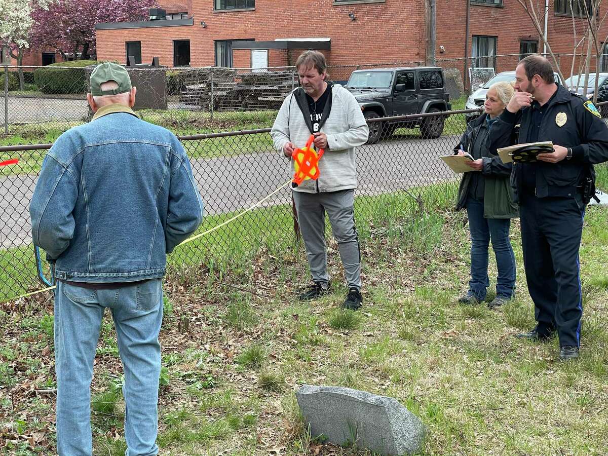 From left, Tony Griego, Randy Guevin, Amy White and David Emerman search for an unmarked grave at State Street Cemetery in Hamden May 3, 2022.