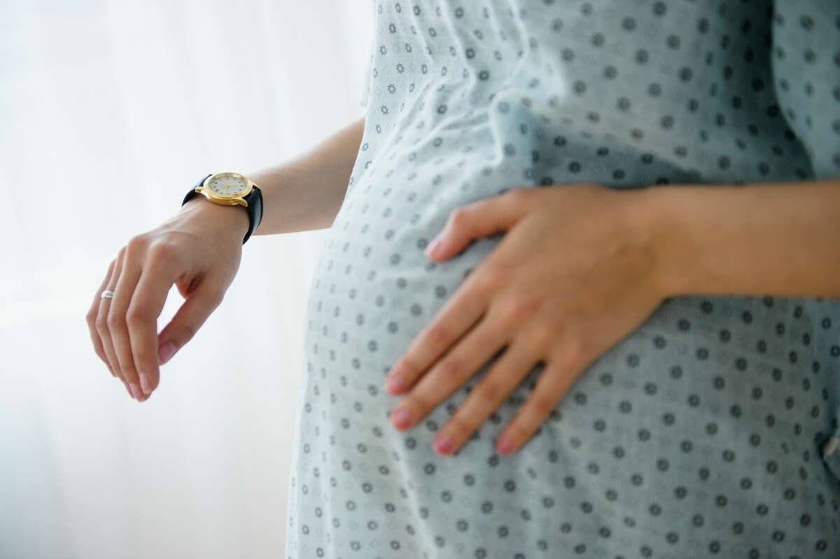 STOCK IMAGE Woman uses watch to time her contractions during labor.