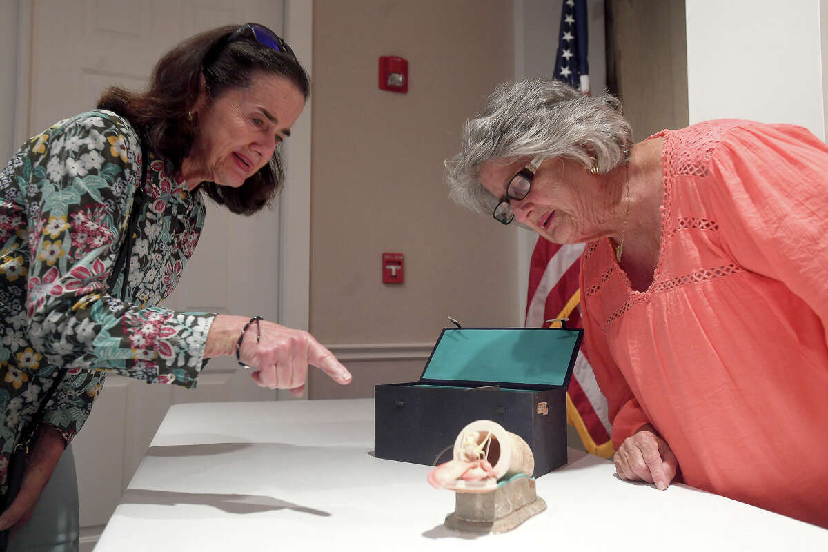 Pat Sherlock (left) and Charlotte Fontenot lean in for a closer look at an ivory piece appraised by Ken Farmer of Antiques Roadshow fame during a free evaluation clinic Friday morning at the McFaddin-Ward House Museum Visitor Center. Photo made Friday, May 13, 2022. Kim Brent/The Enterprise
