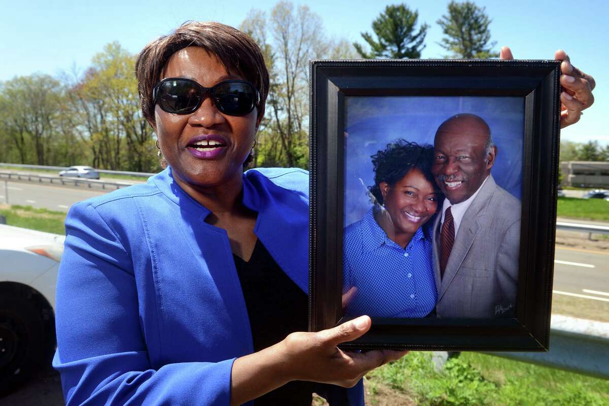 Jolyn Walker holds a portrait of herself and her late husband, Judge, as she speaks during an interview in Milford, Conn. May 11, 2022. Judge Walker, a Milford firefighter, died in 2018.