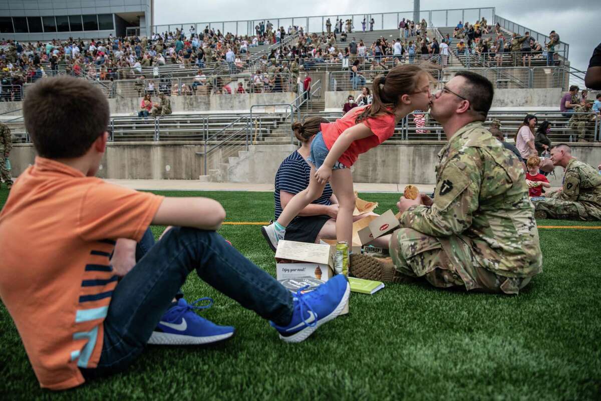 Sgt. Jason Kendrick kisses his daughter Penelope at Kelly Reeves Athletic Complex in Austin as Texas Army National Guard soldiers said goodbye to family and friends before a nine-month deployment to the Middle East in 2020. (Sergio Flores/San Antonio Express News)