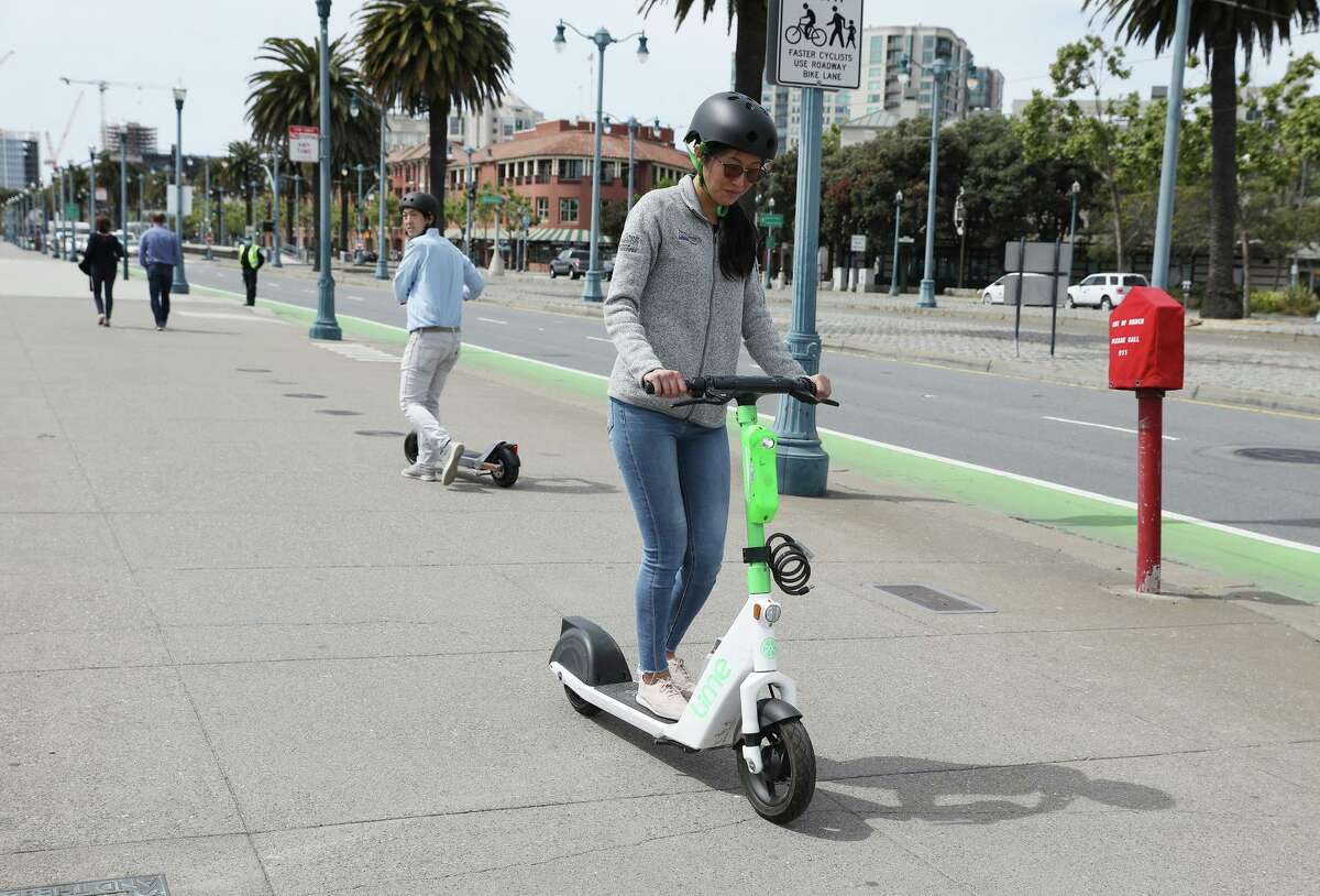 Anissa Chen, senior product manager for Lime, rides one of her company’s scooters during a demonstration by the scooter companies Lime, Spin and Scoot of new technology meant to slow scooters when people ride them on sidewalks.