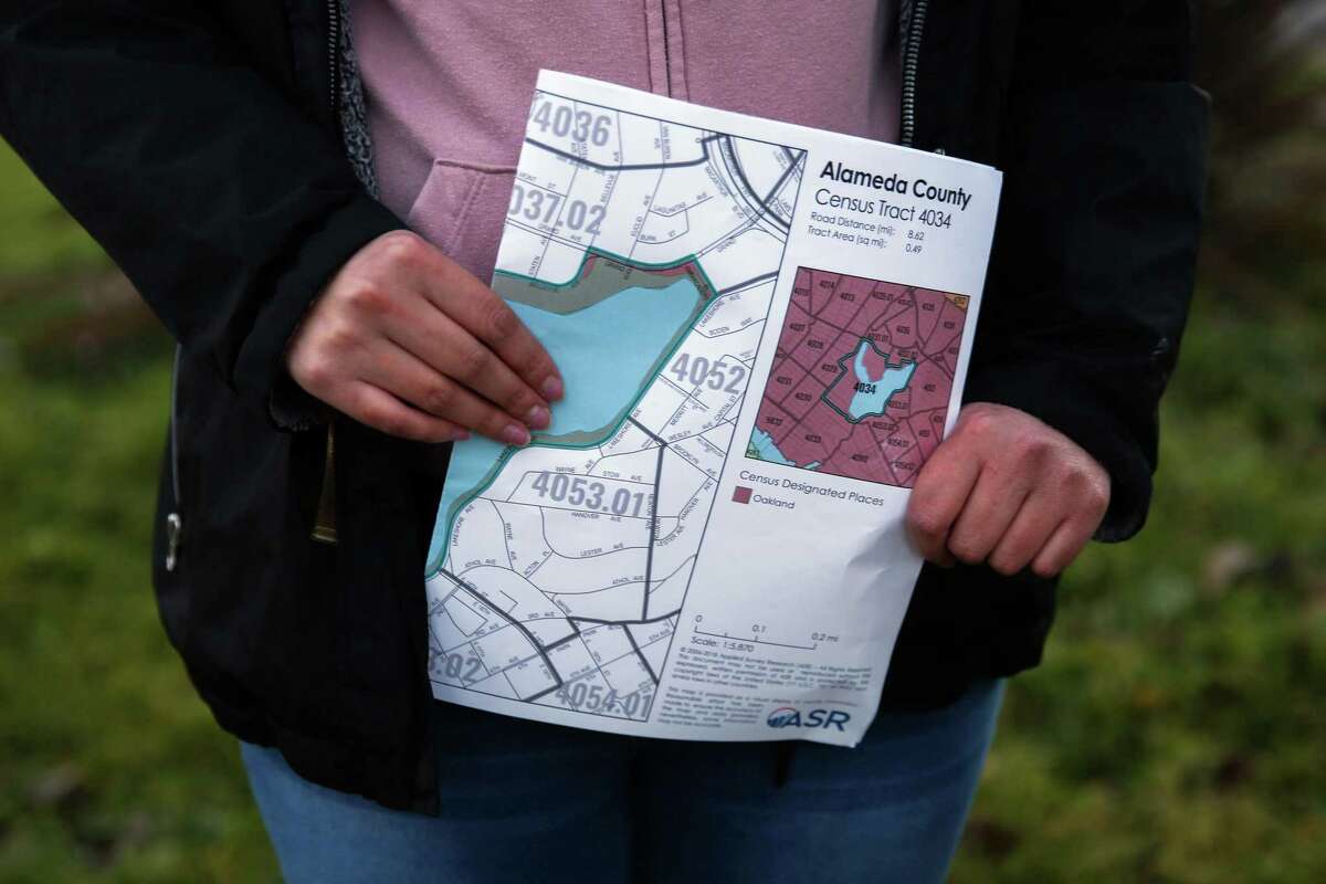 Erika Lua holds map of Lake Merritt as the group is assigned to count any homeless people and encampments they find on Wednesday, Feb. 23, 2022, in Oakland, Calif.