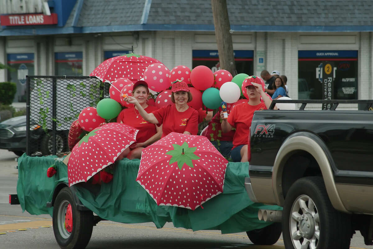 Representatives from the Volunteer Firemen's Association of Pasadena Ladies Auxiliary wave to the crowd during the Pasadena Strawberry Festival parade.